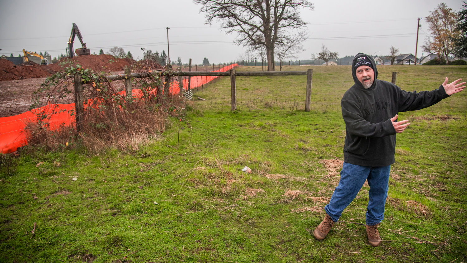 Chad Ruben talks about water that flows through his property during a construction project near his home in Winlock.